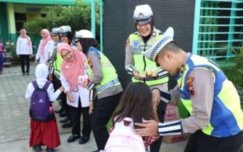 Sambil Atur Lalu Lintas Pagi, Polisi Di Jepara Bagi-Bagi Susu Gratis Ke Siswa SD